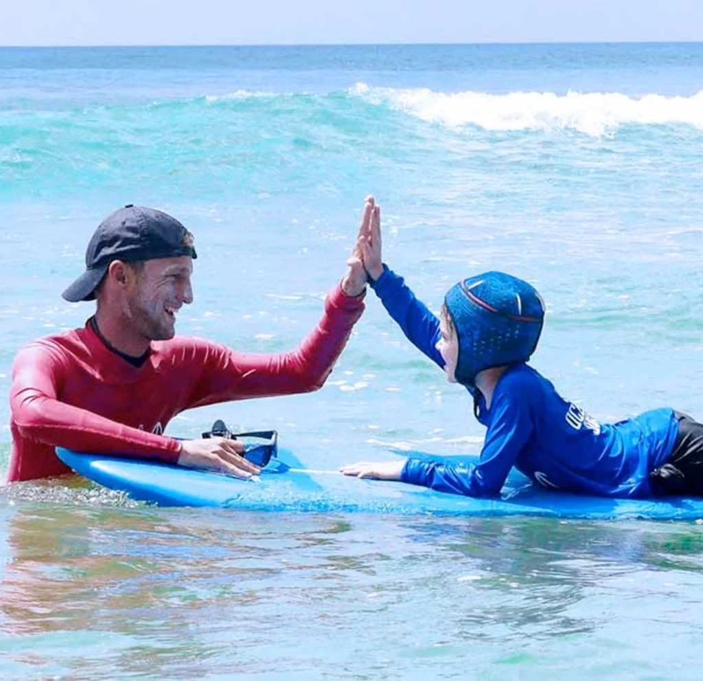 Moniteur félicitant un enfant en stage Jardin du Surf