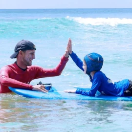 Moniteur félicitant un enfant en stage Jardin du Surf