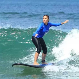 Élève surfant une vague verte en stage Sensation