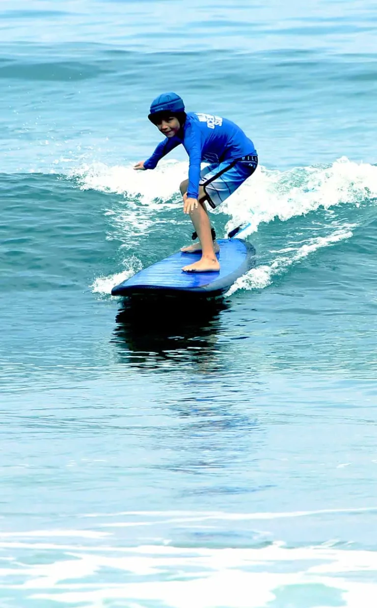 Jeune élève surfant une vague non déferlée en stage à la carte jardin du surf