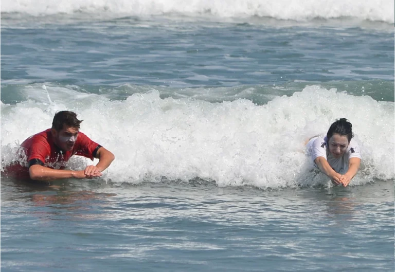 Moniteur et stagiaire en échauffement body-surf durant un stage initiation à la carte