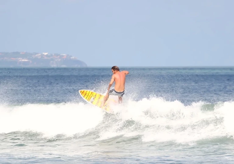 Surfeur expérimenté effectuant une manoeuvre sur une vague