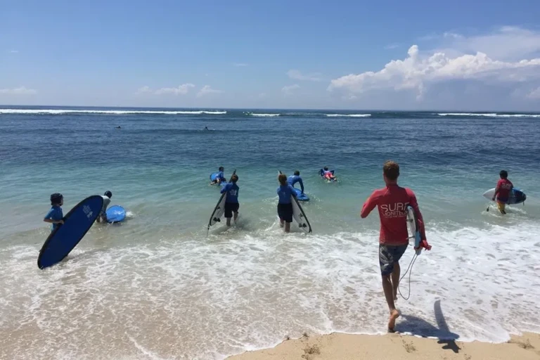 Stagiaires et moniteur courant dans l'eau pour passer les vagues