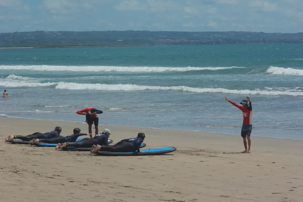 surf coach helping beginner on Legian beach Bali 2026