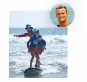 Young child learning to surf with a Bali Ocean Surf coach on Legian beach